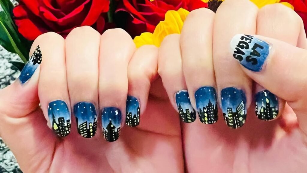 Manicure with a deep blue night sky skyline design and "Las Vegas" lettering on an accent nail