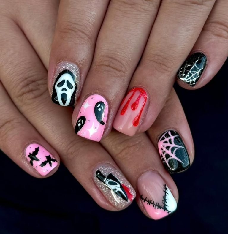 Scary Halloween nail ideas on almond nails with a pink ghost-face drip, glitter silver, black spiderweb, and a white scream mask on a bubblegum pink base