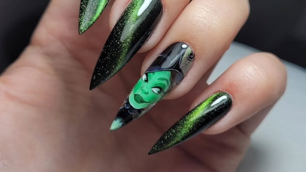 Green witch face nail art accent on a black and emerald ombre stiletto manicure