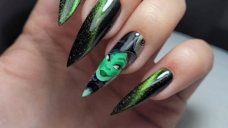 Green witch face nail art accent on a black and emerald ombre stiletto manicure