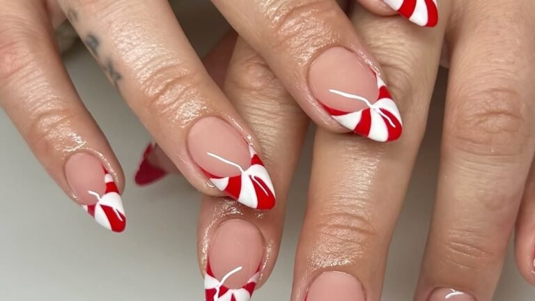 Red and white candy cane striped French tip nails on an almond-shaped manicure