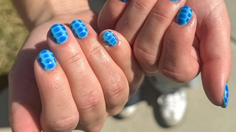 Blue crocodile-print short nail art on cupped hands