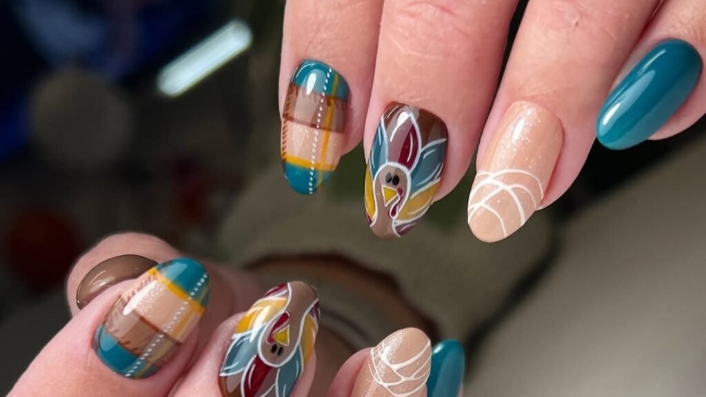 Close-up of a hand showing a Thanksgiving-themed manicure with a hand-painted turkey design, teal accent nails, and brown plaid pattern nails on a nude gel base