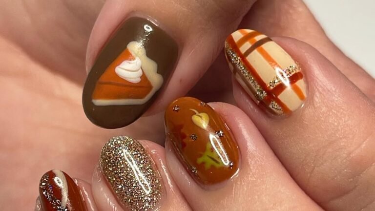 Close-up of a hand-painted pumpkin pie slice nail art design on a matte brown gel nail, part of a Thanksgiving-themed manicure set with plaid and glitter accent nails