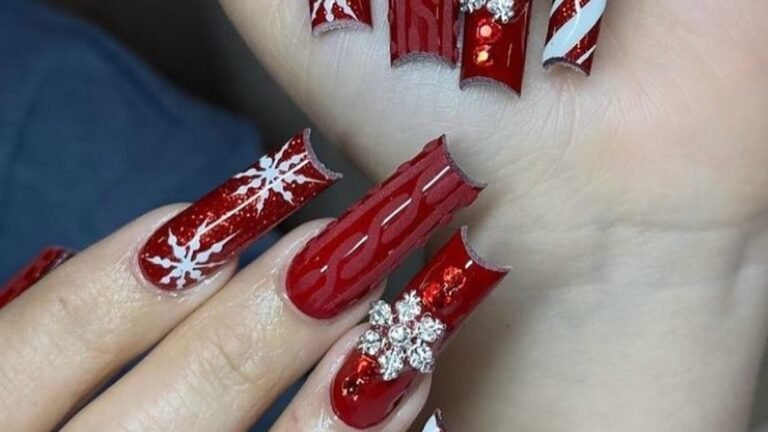 Red glitter Christmas nails with cable-knit texture, white snowflake, and rhinestone accent design