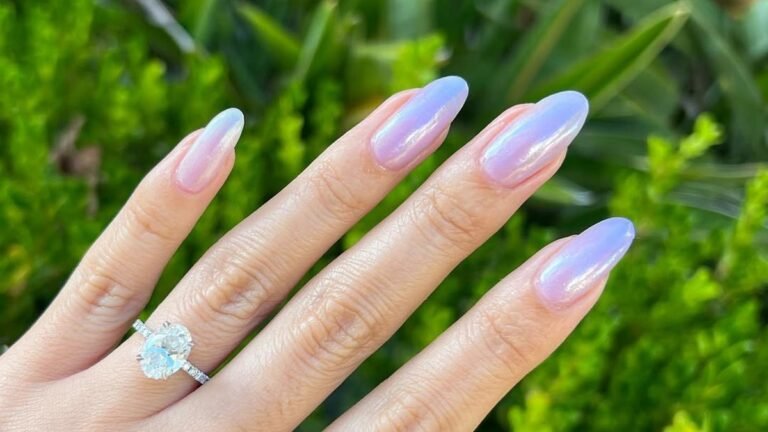 Lavender chrome glazed donut nails with a pearly pink and blue iridescent shift, shown against a bright green garden background
