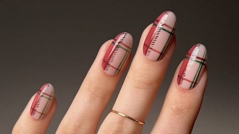 Thanksgiving plaid manicure in wine red and pine green tartan nail art against a soft neutral background