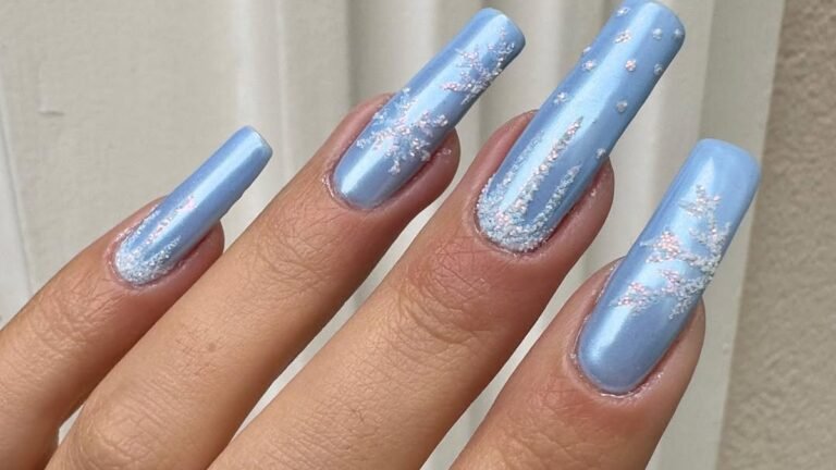 Metallic powder blue nails with silver glitter snowflake nail art, an icy blue winter nail design idea