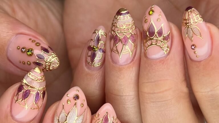 Nude wedding nails with fine gold filigree linework and purple jewel accents
