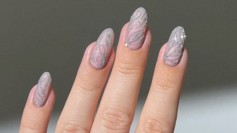 Sheer pink almond nails with fine silver glitter line art, close up shot