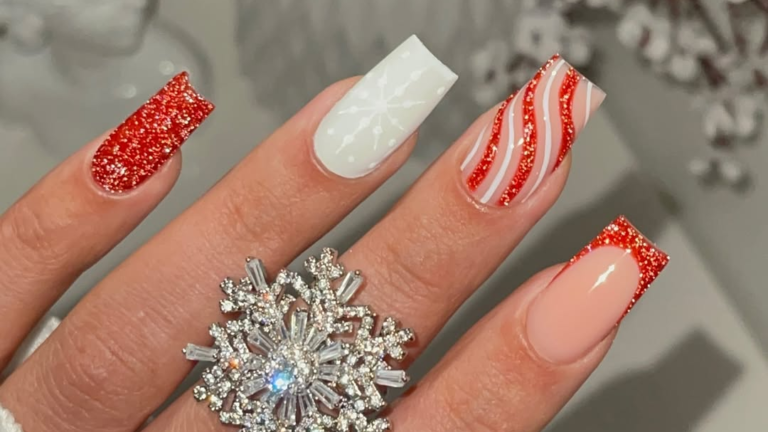 Red glitter and white snowflake winter nail design with candy cane striped accent nail