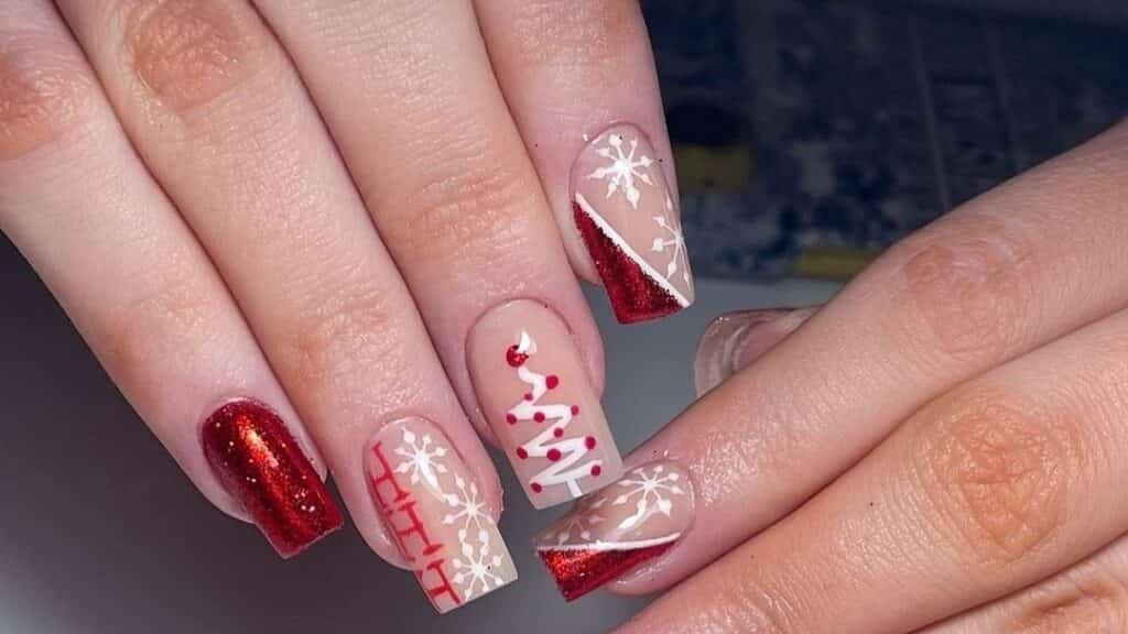 Red Christmas manicure with matte nails, a glitter accent nail, and a hand-painted snowflake design on a pink and red tip