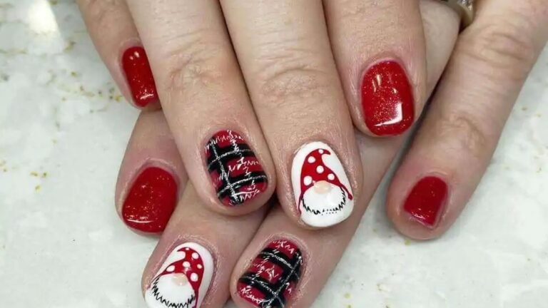 Red manicure with one white accent nail featuring a hand painted Christmas gnome design