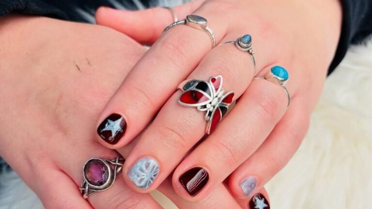Long square nails with white French tips and delicate white snowflake nail art over a pinkish nude base