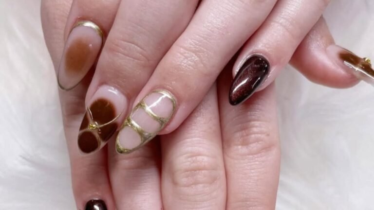 Neutral winter manicure with cocoa brown nails, gold negative-space line art, and a glossy dark accent nail