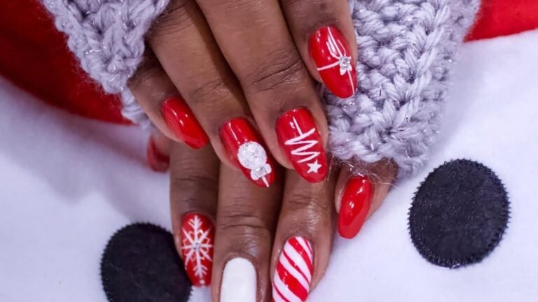 Red and white Christmas nails with a candy cane stripe, snowflake, and ornament rhinestone accent