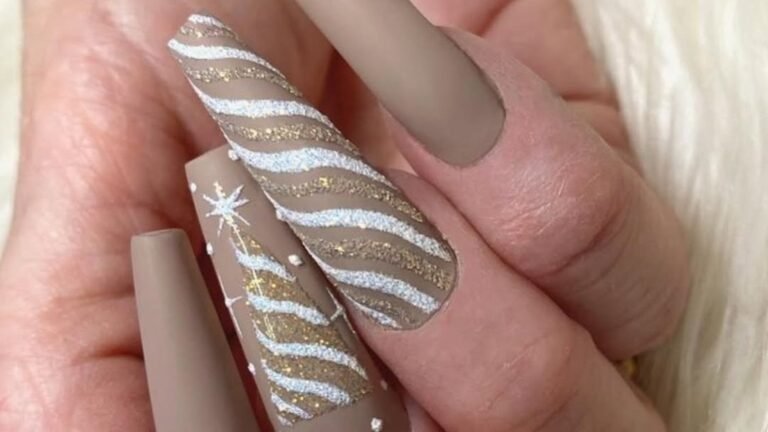 Matte mocha nude nails with a glitter Christmas tree accent nail and silver gold striped design, nude winter nail ideas