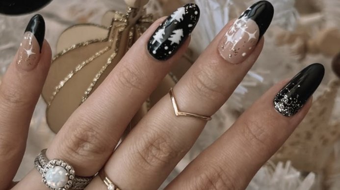 Glossy black winter nails with hand-painted pine tree and snowflake accents on deep color