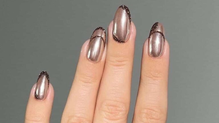 Chrome mocha manicure with a dark glitter cuticle outline on almond-shaped nails