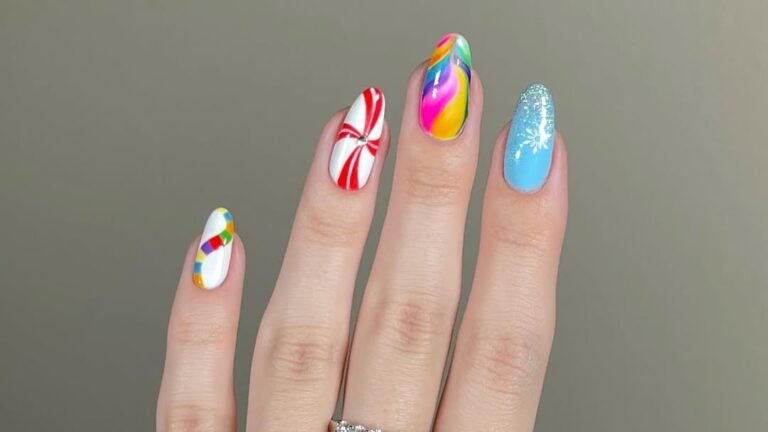Four short winter nail designs featuring red and white candy cane stripes, a rainbow swirl, and a glittery light blue nail with a white snowflake accent