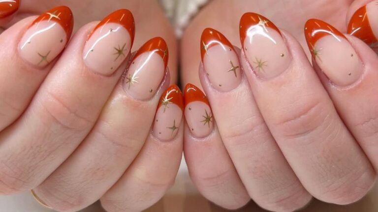 Rust orange French tip manicure with gold star nail art on warm neutral nails, ideal for a November nail look