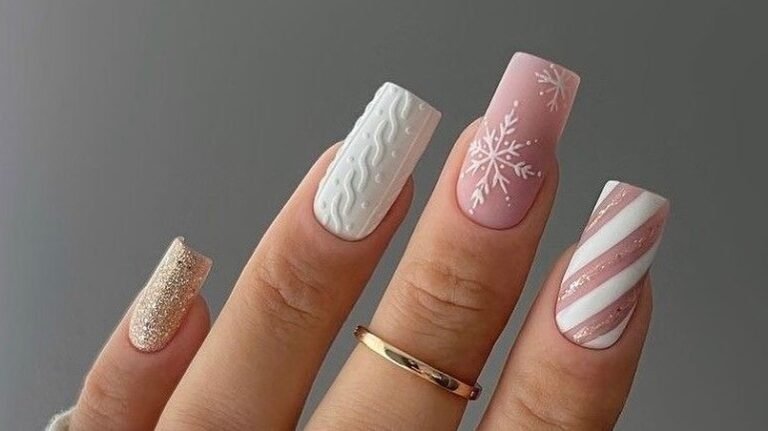 Blush pink winter manicure with snowflake, sweater-knit, and candy cane stripe nail art designs
