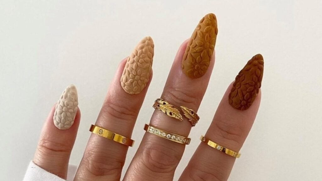 extured floral-embossed manicure fading from caramel to dark espresso brown across four fingers