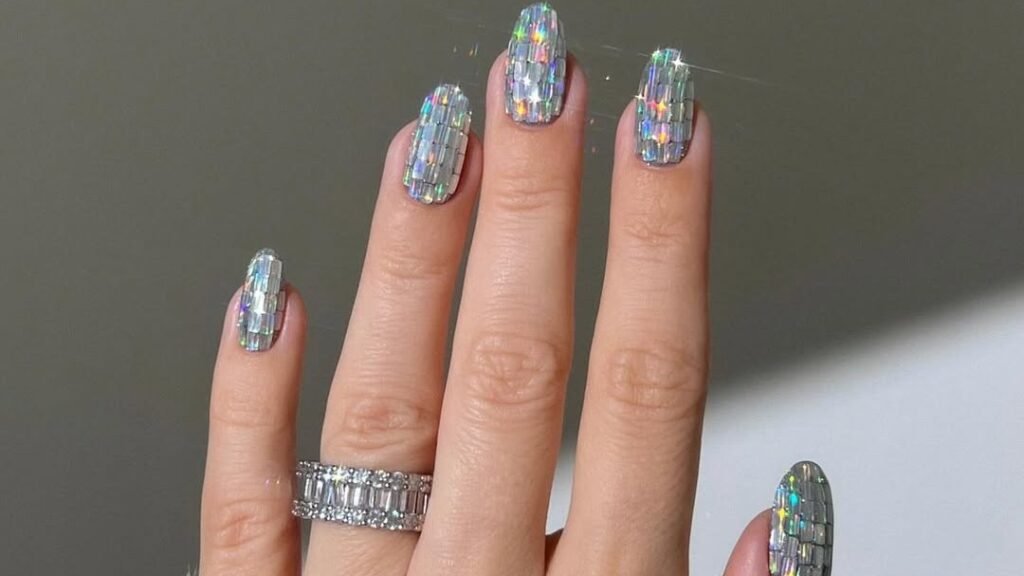 Holographic silver glitter nails with rainbow sparkle, sparkly winter nail art idea