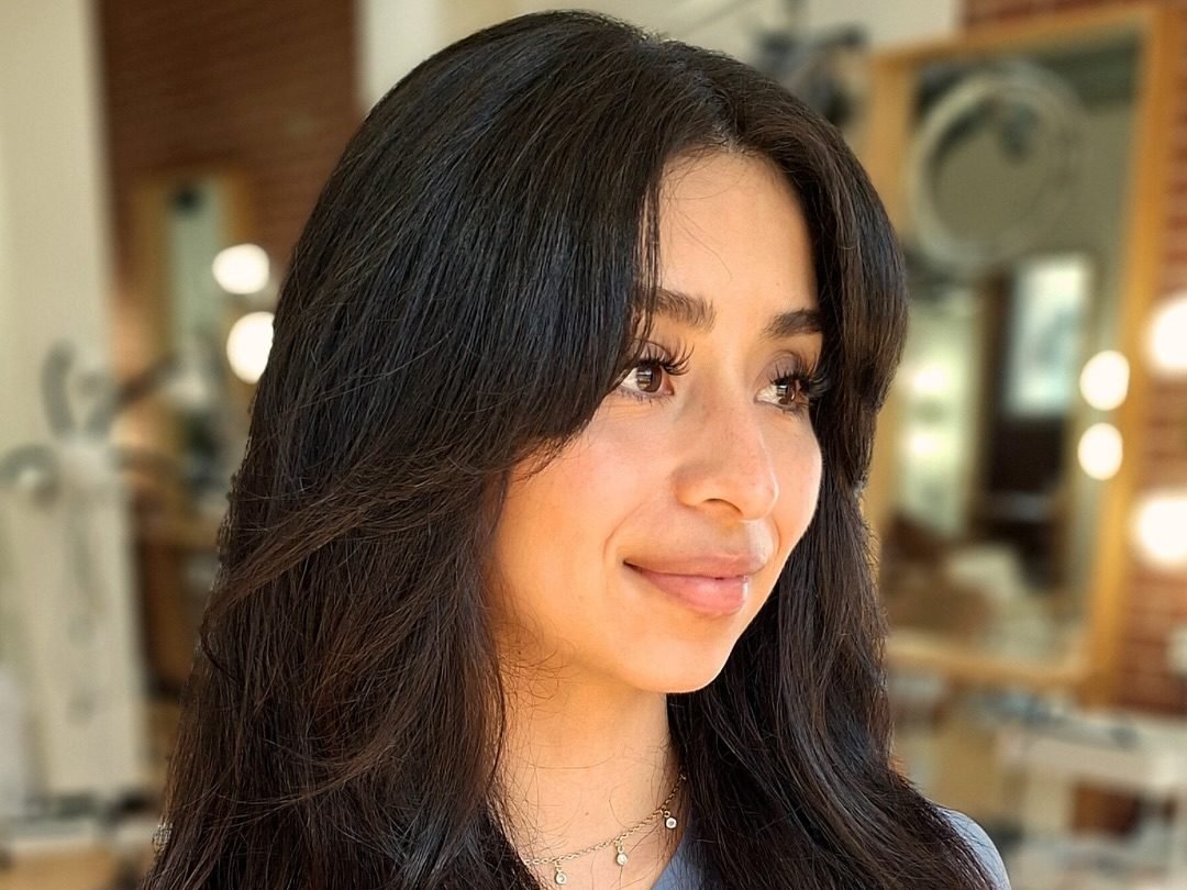 Long, layered hair in salon setting.