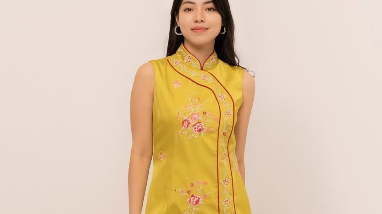 Mustard yellow embroidered qipao dress with red piping and floral motifs, one of 5 Lunar New Year dress ideas with a single print and no extra layering