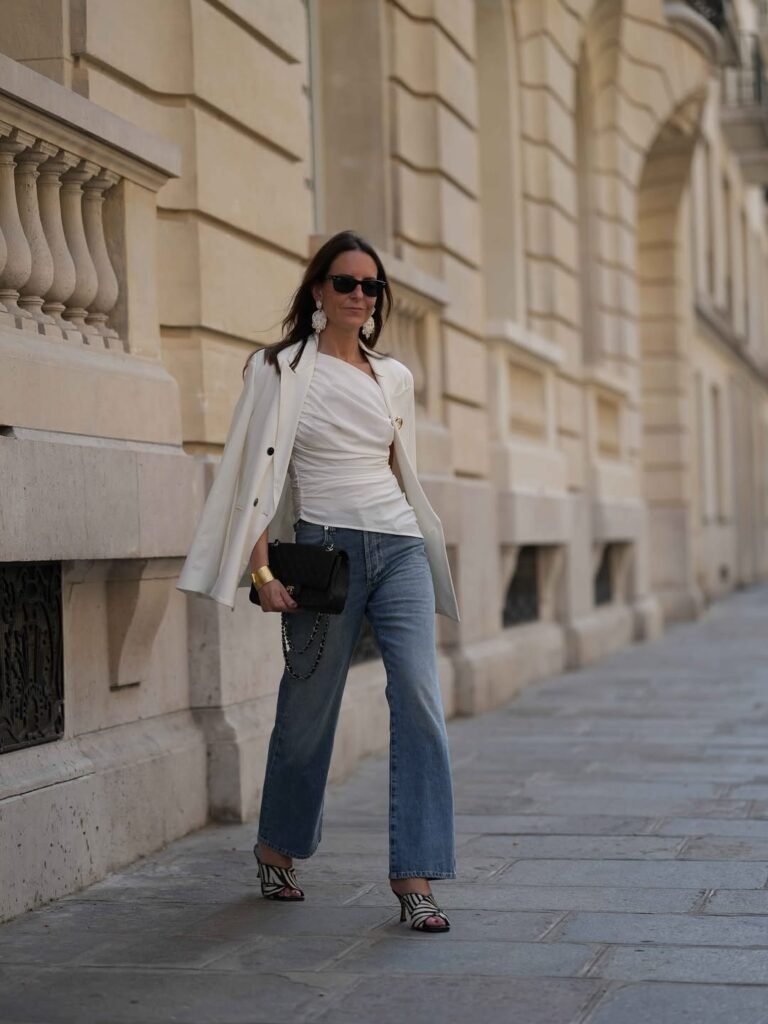 Light wash jeans styled with a bright floral blazer over a cropped denim top, showing how light wash denim works as a base for a bold statement layer