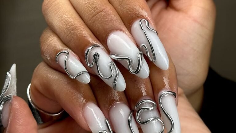 White glossy nails with raised silver metallic ribbon linework traced on top, not painted solid