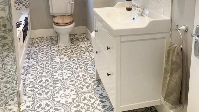 White subway tile bathroom with dark vanity and black-and-white patterned floor