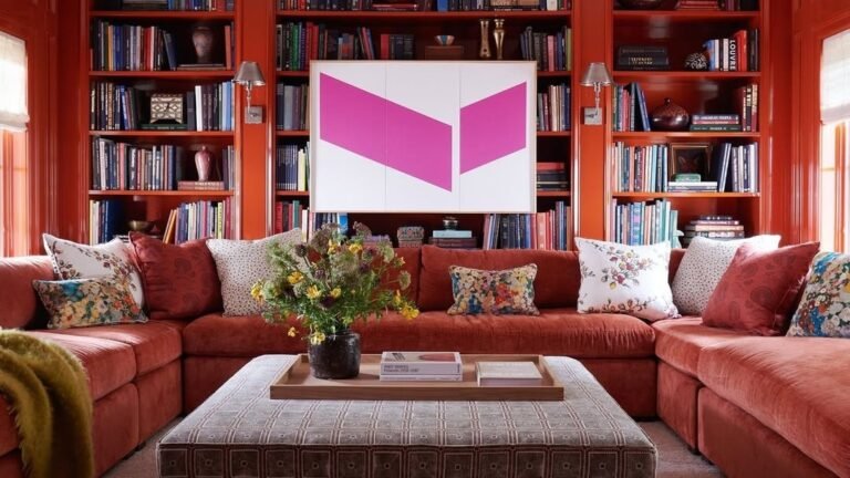 Living room with floor-to-ceiling red lacquer bookshelves, a red sectional sofa, and a bold pink geometric art panel as the focal point