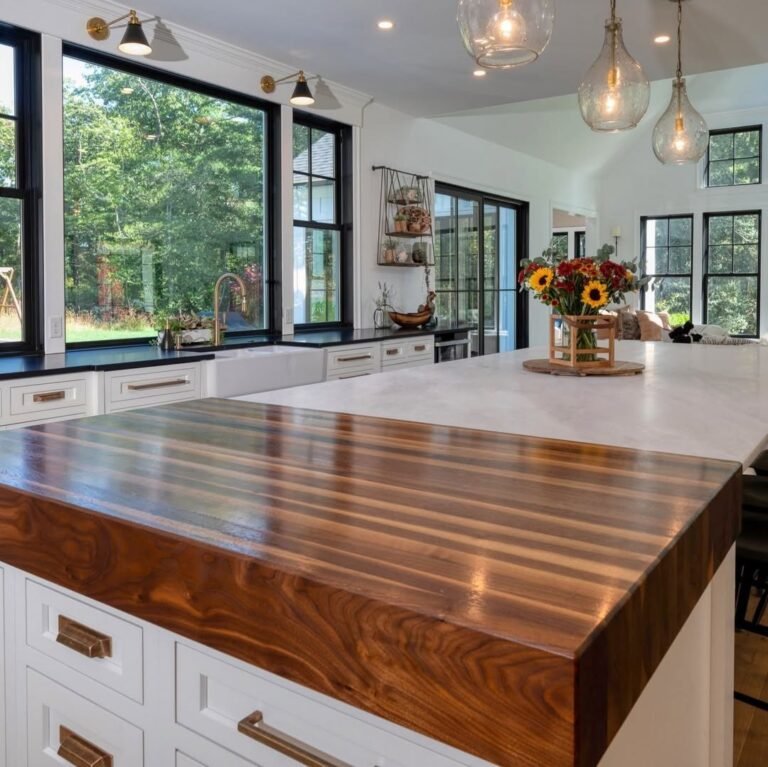 Dark navy kitchen island with a rich end-grain walnut butcher block countertop and integrated sink