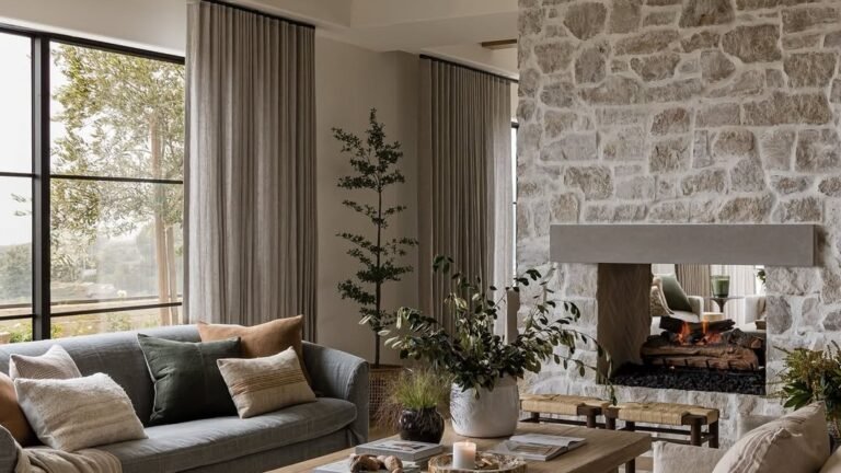 Rectangle living room with two sofas clustered on a rug facing a stone fireplace wall, open floor space at the room's edges