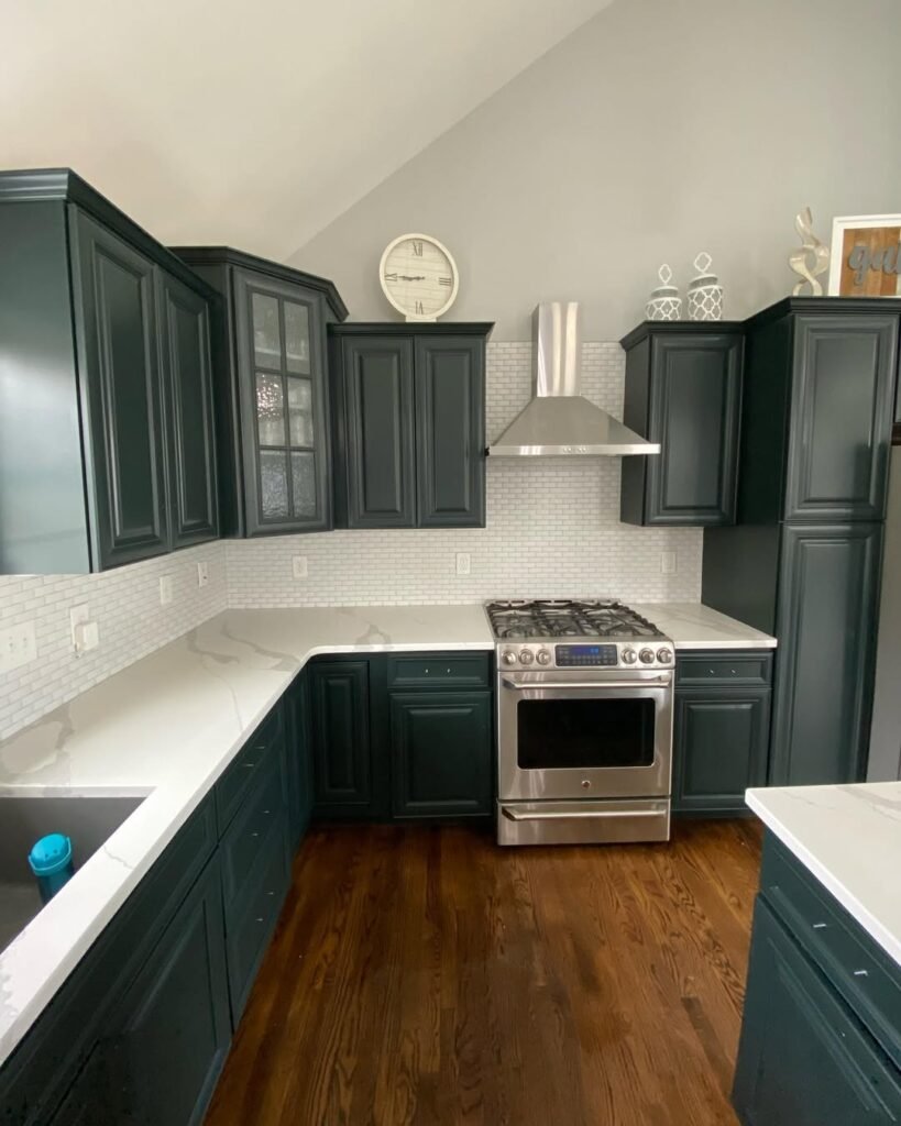 Deep forest green kitchen cabinets with brass hardware and white marble countertops