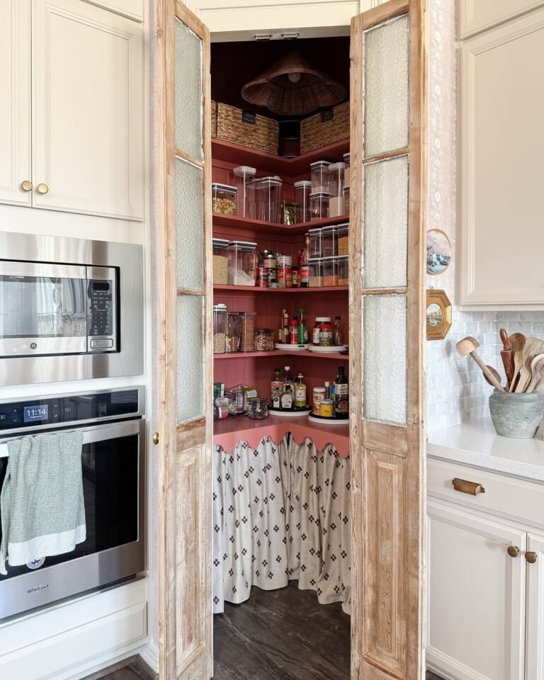 Pink corner pantry with reclaimed wood doors and wraparound shelving filled with jars and baskets