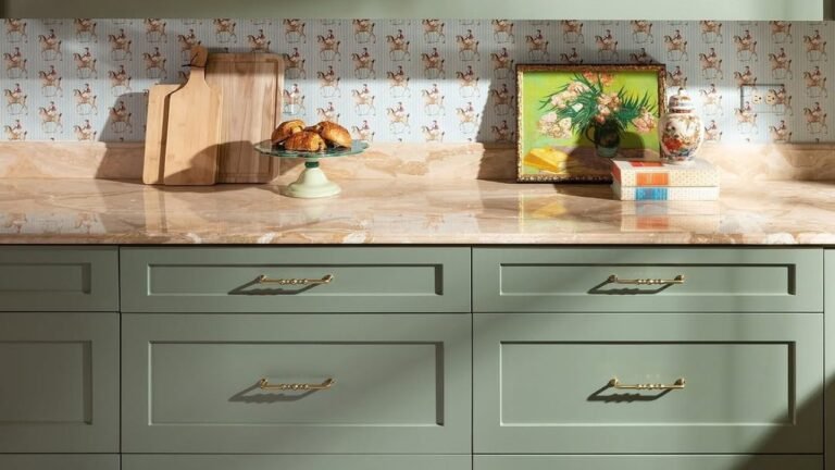 Sage green open shelving and drawers with ornate brass scroll cabinet pulls and scalloped trim
