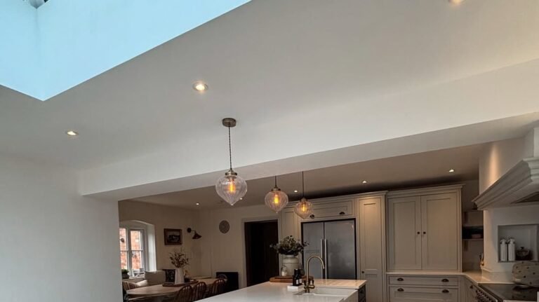 Navy blue kitchen island with white countertop under a large skylight, part of a dream kitchen ideas roundup where no two kitchen styles repeat