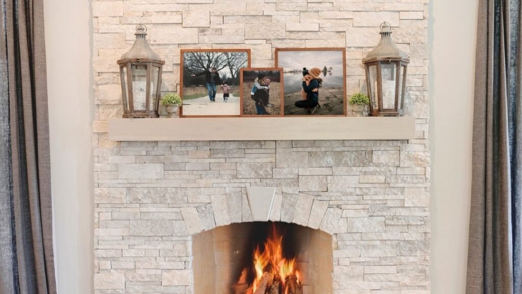 Light stacked stone fireplace mantle styled with wood lanterns and framed family photos