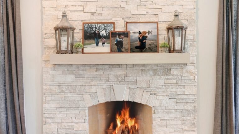 Light stacked stone fireplace mantle styled with wood lanterns and framed family photos