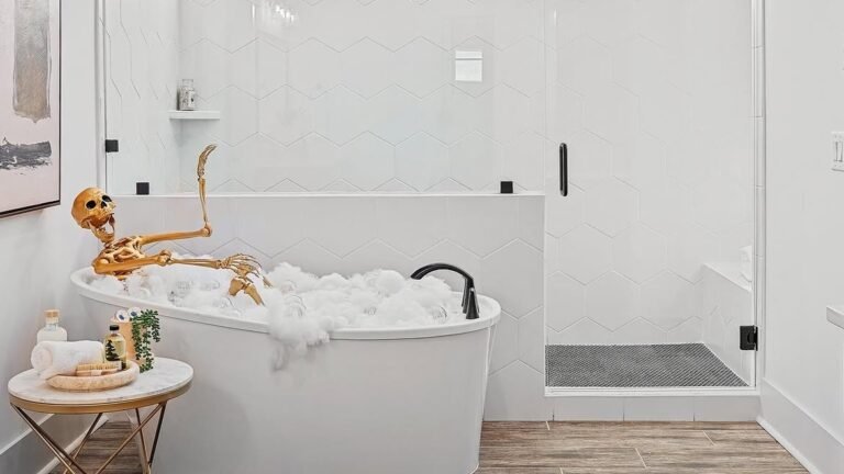 Gold skeleton relaxing in a bubble bath in a white marble Halloween bathroom