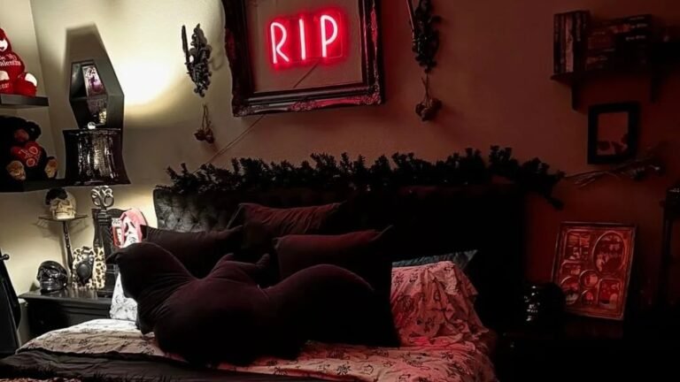 Neon RIP sign glowing above a leopard print Halloween bedroom with a cow skull mount and candle sconces