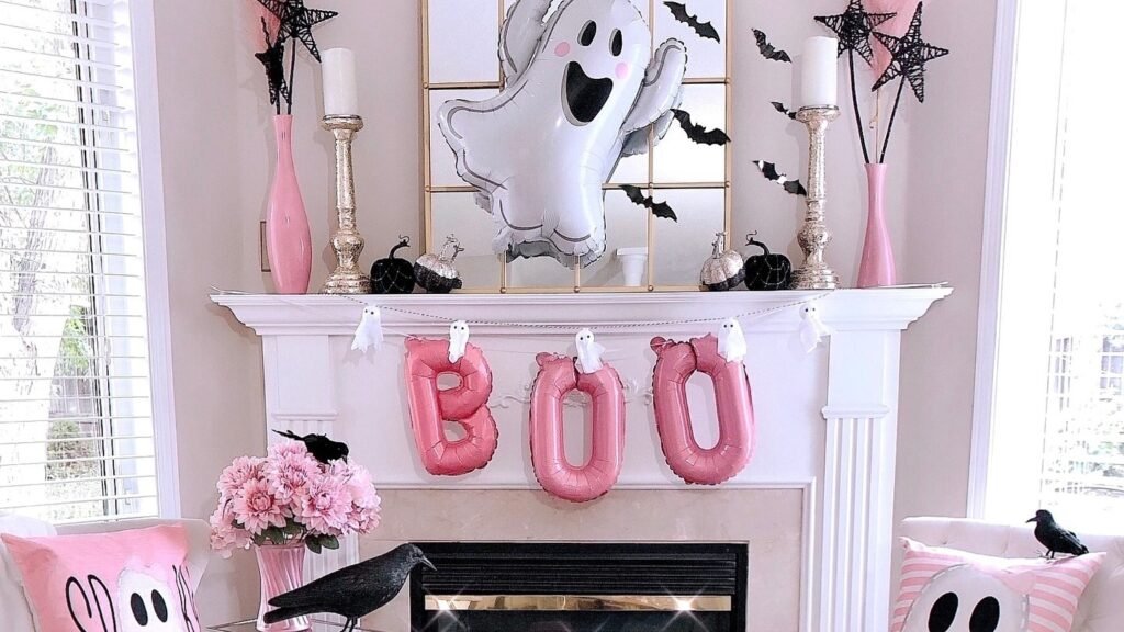 Pink Halloween living room with a pink BOO balloon banner on the mantel and pink ghost throw pillows on white armchairs