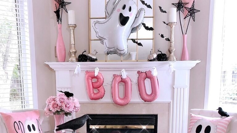 Pink Halloween living room with a pink BOO balloon banner on the mantel and pink ghost throw pillows on white armchairs