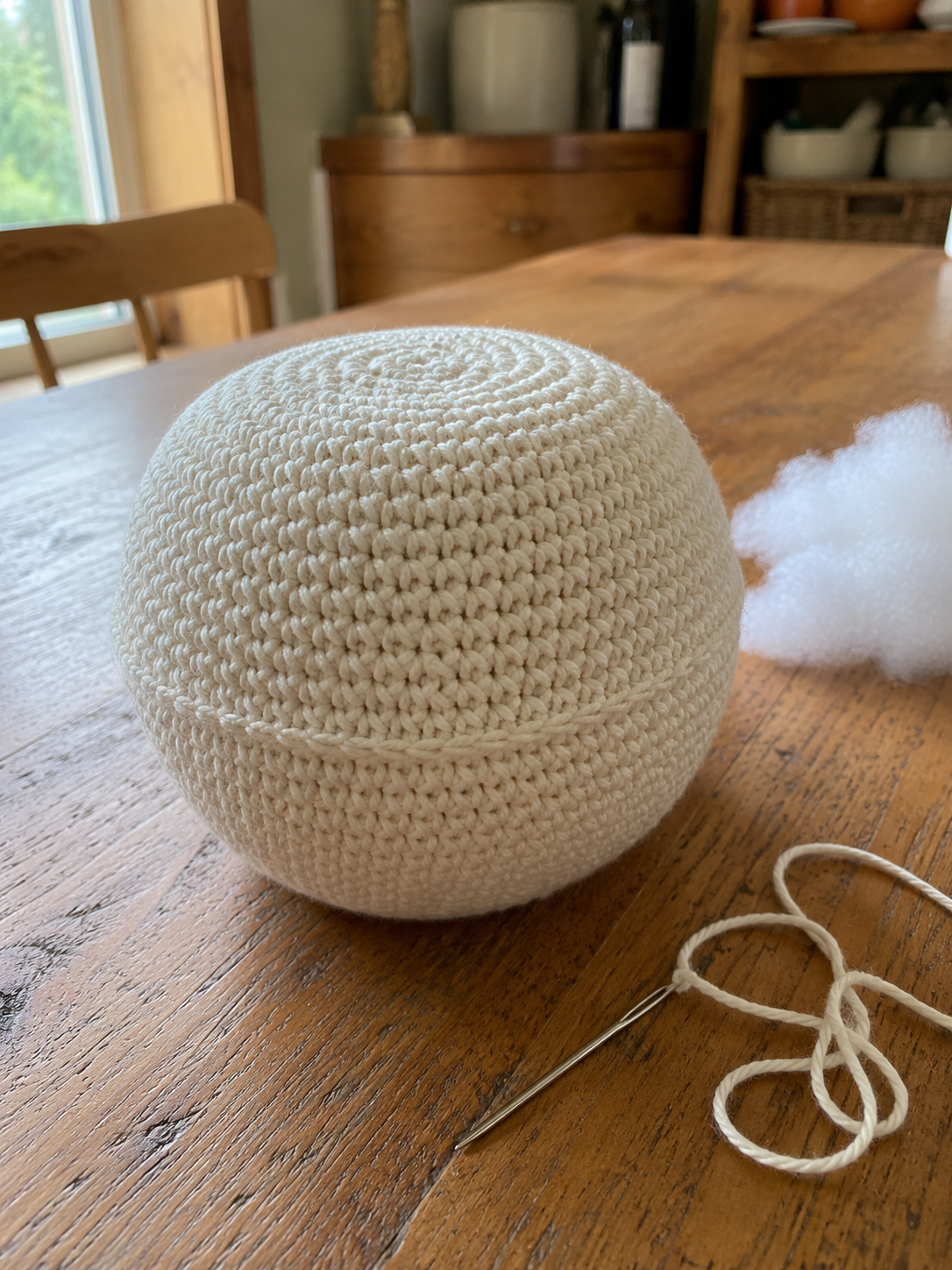 Stuffed crochet pumpkin sphere before adding ribs with polyester fiberfill and yarn needle