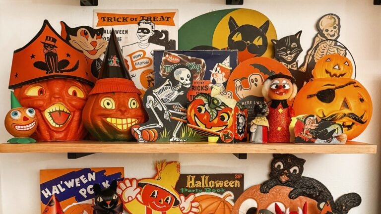 Vintage Halloween decor shelf with orange blow mold jack-o-lanterns, a tin litho skeleton, and a witch figure grouped together