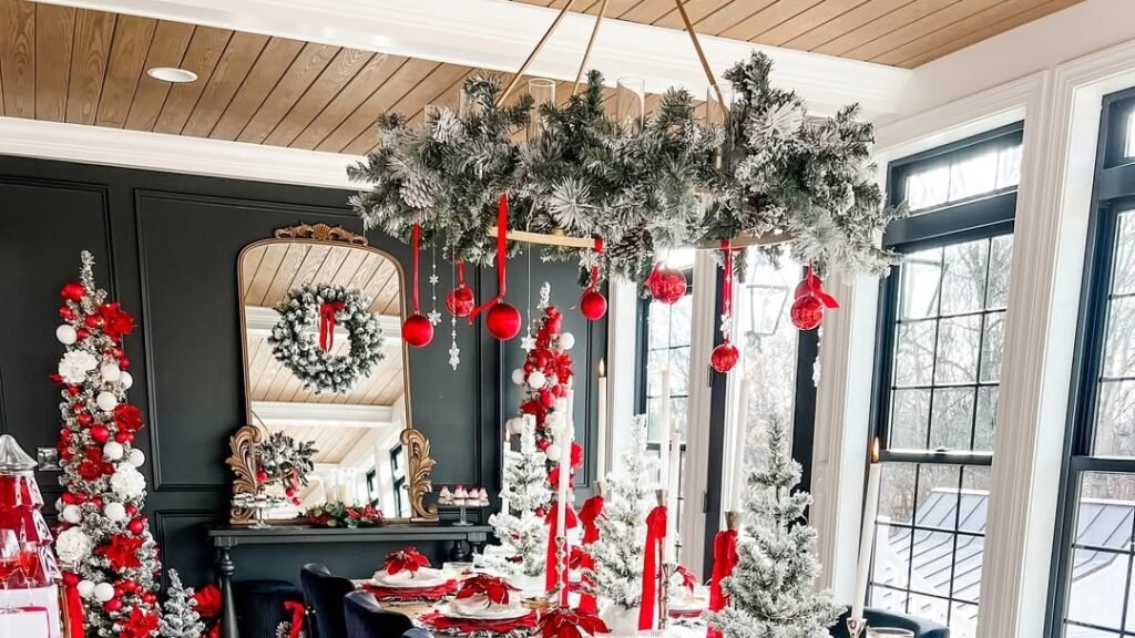 Flocked chandelier decorated with hanging red ball ornaments above a Christmas dining table