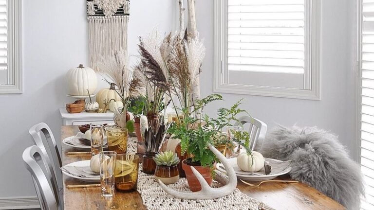 Boho Thanksgiving table with a macrame fringe runner, pampas grass, and white pumpkins on a wood table